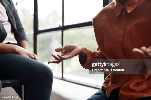 businesswoman gesturing by window at workplace - gesturing stock pictures, royalty-free photos & images