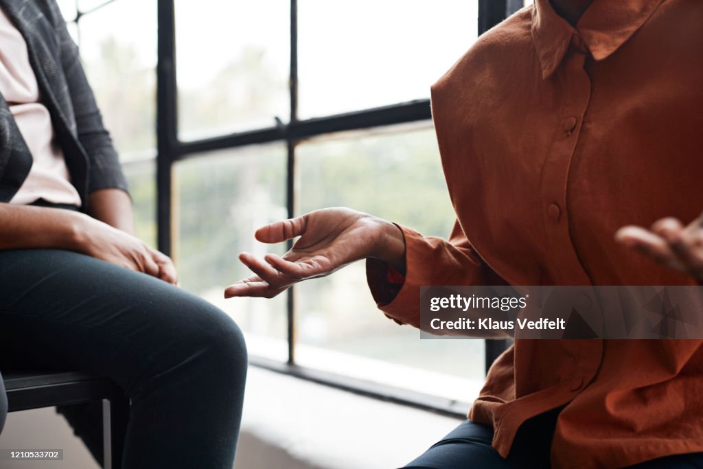 Businesswoman gesturing by window at workplace
