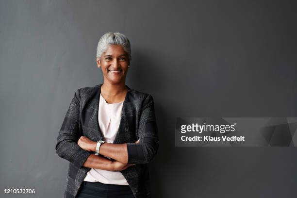 smiling businesswoman standing in board room - black blazer foto e immagini stock