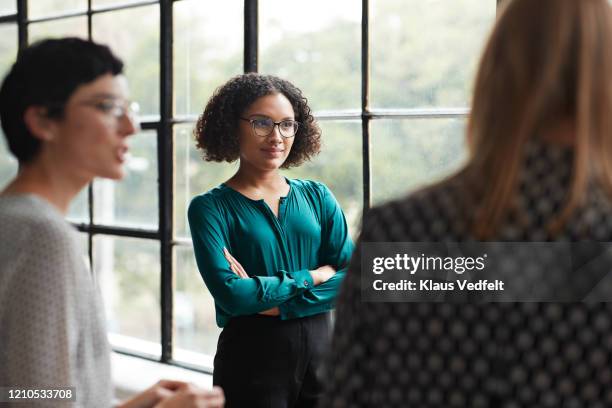 entrepreneur with arms crossed at modern workplace - facial expression girl office stock pictures, royalty-free photos & images