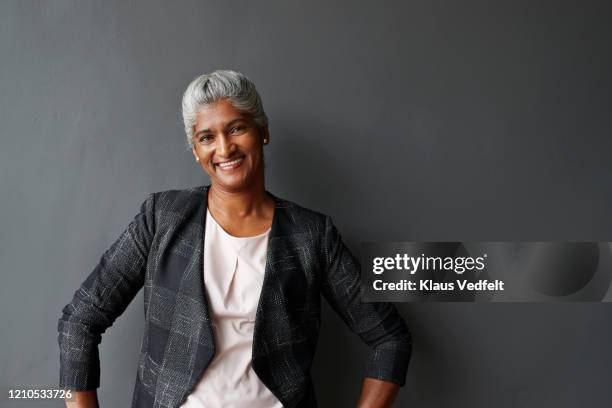 smiling mature businesswoman in office board room - grey hair stock pictures, royalty-free photos & images