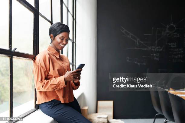 smiling entrepreneur using phone in office meeting - business finance and industry stock pictures, royalty-free photos & images