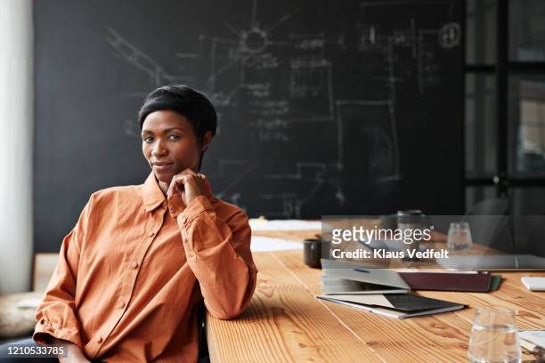 confident entrepreneur sitting in board room - determination stock-fotos und bilder