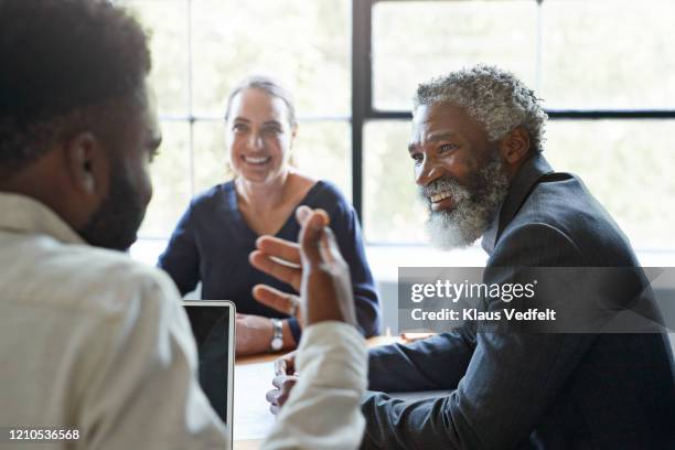 businessman looking at coworker in office meeting - senior executives stock-fotos und bilder