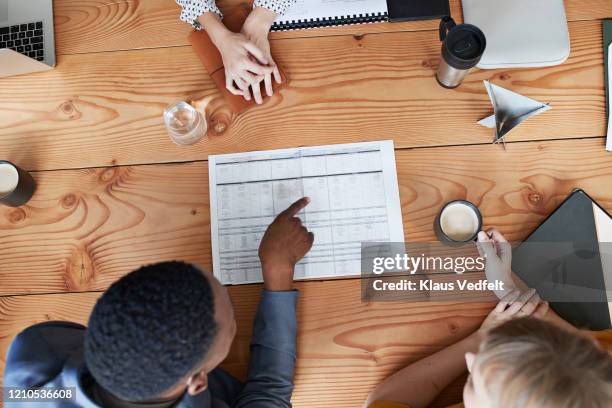 business professionals discussing plan in meeting - table top view stock-fotos und bilder