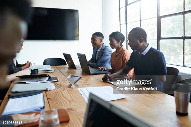 entrepreneur with colleagues in office meeting - business people group brown stock pictures, royalty-free photos & images