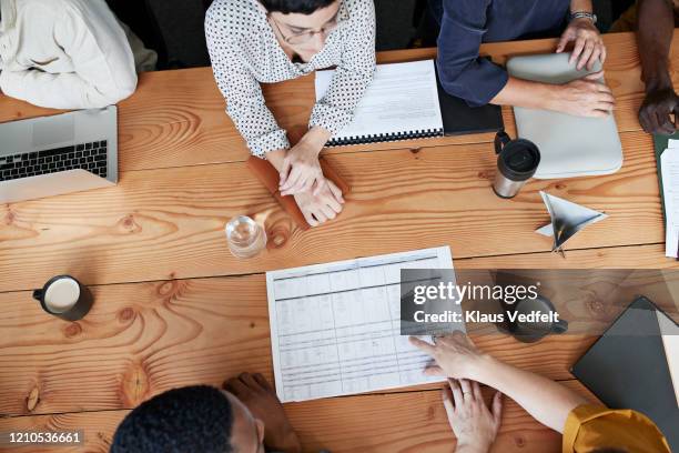 business people discussing at table in office - plant from above stock-fotos und bilder