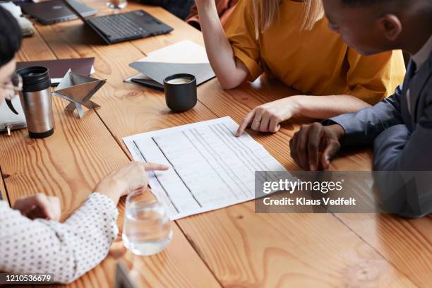 business people discussing at table in office - piano aziendale foto e immagini stock