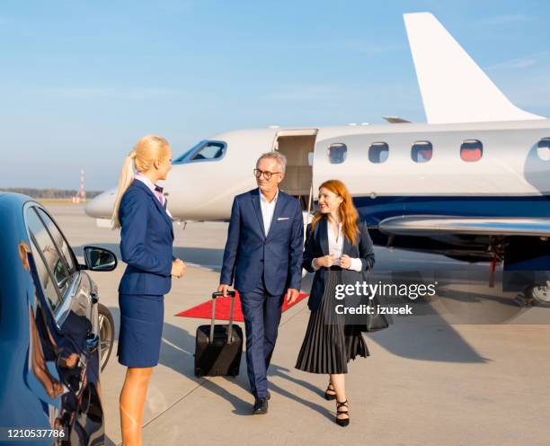 uomini d'affari di fronte a un jet privato in aeroporto - vip airport foto e immagini stock