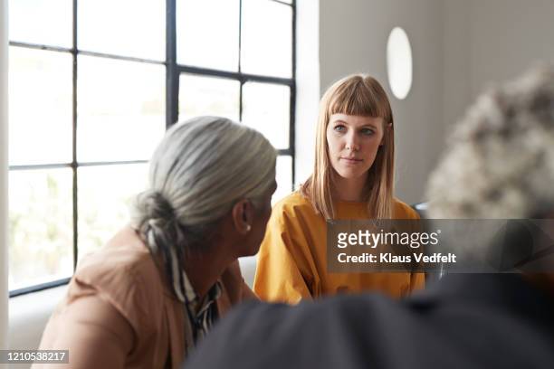 entrepreneur looking at coworker at workplace - business people group brown stock pictures, royalty-free photos & images