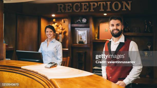 receptionists at work in hotel - bellhop stock pictures, royalty-free photos & images