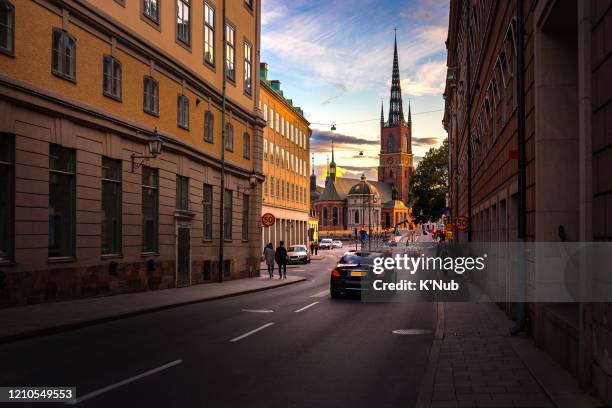 sunset view behind riddarholmen chruch in old town, famous landmark in stockholm city, with tourist and taxi for transportation on road in stockholm city, sweden, europe, scandinavia - stockholm city stock-fotos und bilder