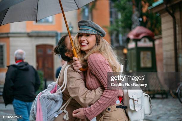 happy woman embracing her female friend - stockholm old town stock pictures, royalty-free photos & images