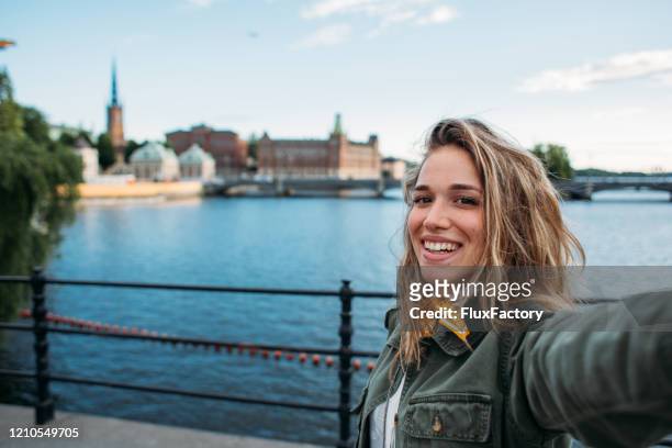 modern fashionabel kvinna tar foto av hersefl framför gamla stan - stockholm bildbanksfoton och bilder