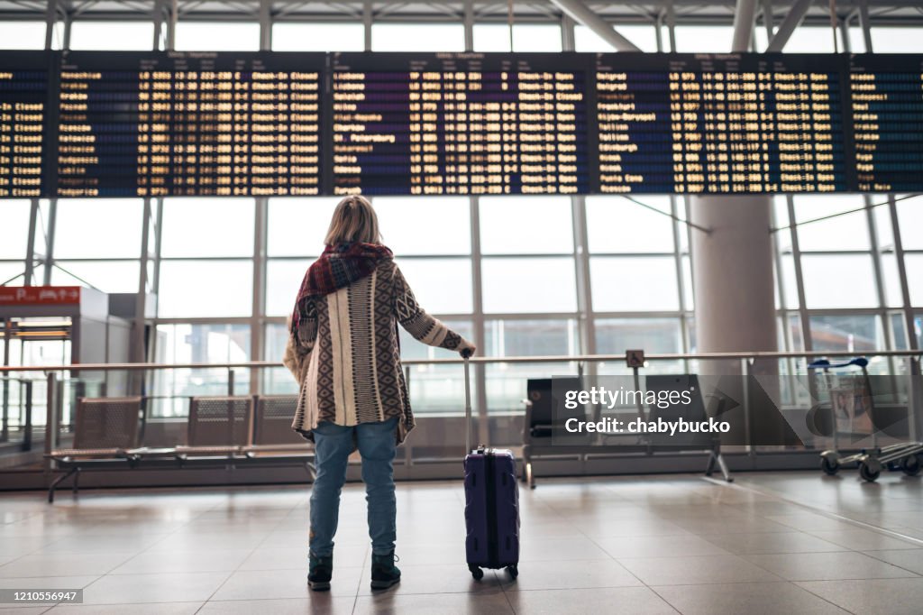 空港で出発ボードを読む女性