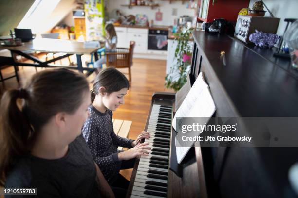 In this photo illustration a mother or a teacher gives piano lessons on April 16, 2020 in Bonn, Germany.