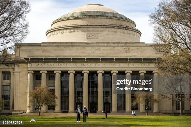 People stand on the lawn outside Building 10 on the Massachusetts Institute of Technology campus in Cambridge, Massachusetts, U.S., on Monday, April...