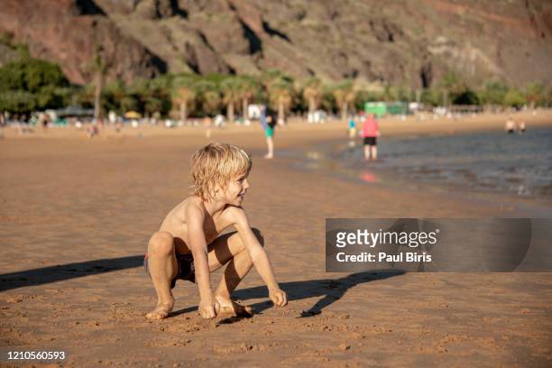 little boy playing on the beautiful beach in canary island, las teresitas,tenerife,spain - san andres stockfoto's en -beelden
