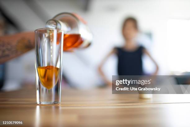 In this photo illustration a child looks at the parents pouring an alcoholic beverage, a gin, on April 15, 2020 in Bonn, Germany.