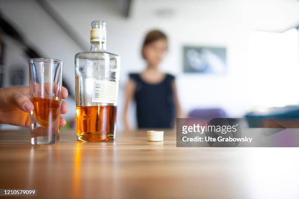 In this photo illustration a child looks at the parents pouring an alcoholic beverage, a gin, on April 15, 2020 in Bonn, Germany.