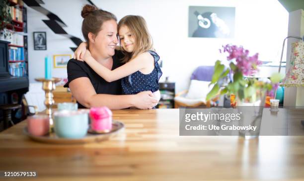 In this photo illustration a mother and a seven year old girl are sitting cheek to cheek on April 15, 2020 in Bonn, Germany.