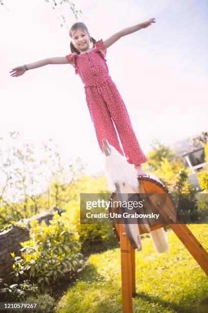 In this photo illustration a girl balances on a horse made from wood on April 15, 2020 in Bonn, Germany.