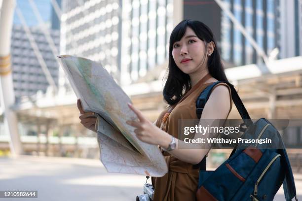 young solo traveler woman in singapore street market checking the map - wonderlust stockfoto's en -beelden