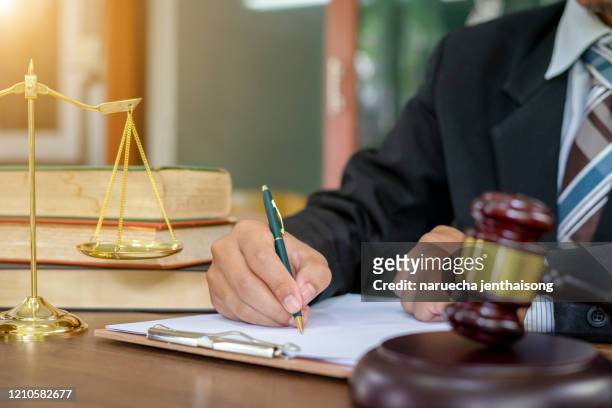 lawyer working on wooden desk with gavel and soundblock of justice law - procedimento giudiziario foto e immagini stock
