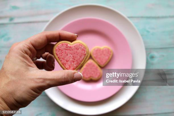hand holding heart shaped cookies - dessert stand stock pictures, royalty-free photos & images