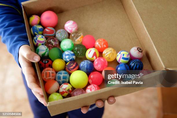 boy holding box with toy balls - bouncing ball stockfoto's en -beelden