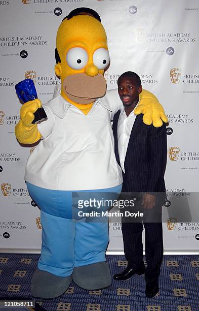 Shaun Wright Phillips and Homer Simpson pose for pictures in the Press Room of 12th British Academy Children's Awards at the London Hilton Park Lane...