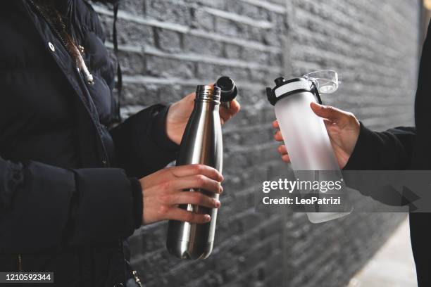 femmes faisant de l’exercice à l’extérieur dans la rue de ville dans un jour pluvieux à londres - bouteille d'eau photos et images de collection