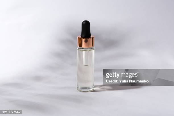 beauty skincare concept template - dropper glass bottle with cosmetic oil or serum, natural hard light, deep shadows on gray background. - acid attacks stock pictures, royalty-free photos & images