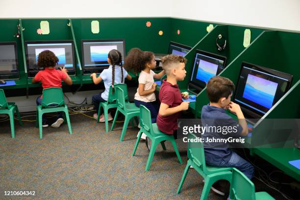 basisschool oude spaanse schoolkinderen in computerlaboratorium - digital devices beside each other stockfoto's en -beelden