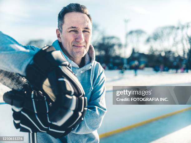 vater spielt hockey im freien - ice hockey player stock-fotos und bilder