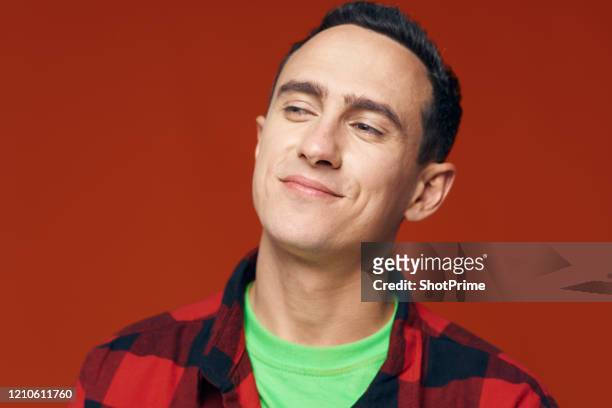 contented calm and confident alpha male squinted and pretty looks away, red background, checkered shirt - people speaking great background stock pictures, royalty-free photos & images