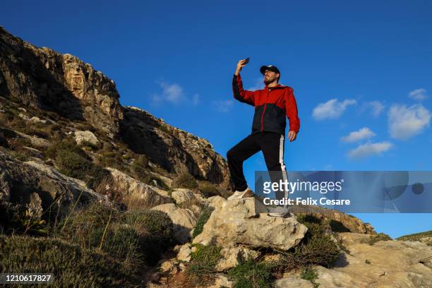 a young tourist hiking and taking photos - malta wandern stock-fotos und bilder