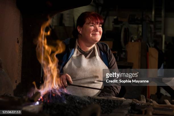 a female steel worker sat by a forge - femalefocuscollection stock-fotos und bilder