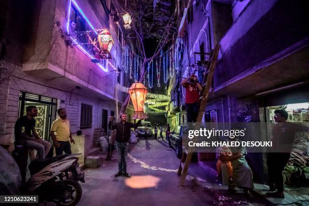 Egyptian youths decorate their residential street in preparation for the Muslim holy month of Ramadan in Cairo's Hadayek el-Maadi district, on April...