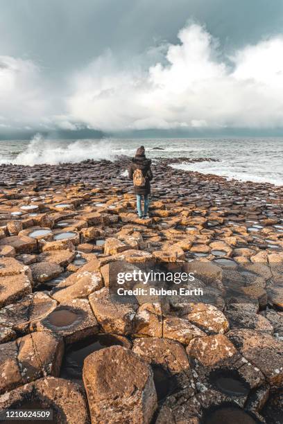 a wave hits the basalt column landscape - pentagon road stock pictures, royalty-free photos & images