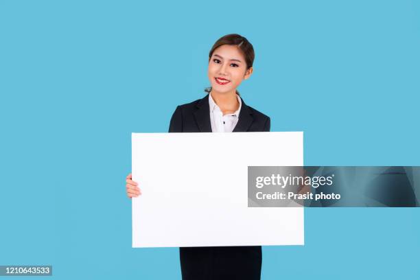 banner of young happy asian businesswoman in suit feeling happiness and holding empty white canvas frame for text or business advertising isolated on cyan background - blank canvas imagens e fotografias de stock