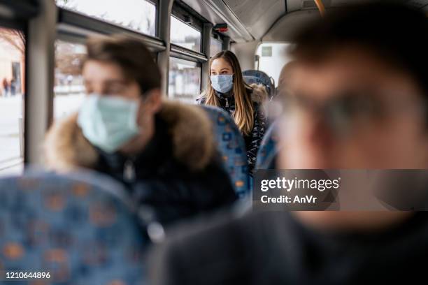 young girl wearing sterile face mask using a public transport - 2020 mask stock pictures, royalty-free photos & images