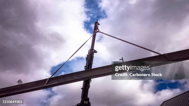 mobile crane lifting an iron beam - perfil doble t fotografías e imágenes de stock