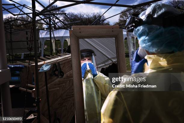 Medical workers putting on PPEs at the beginning of their shift at the emergency field hospital run by Samaritan's Purse and Mount Sinai Health...