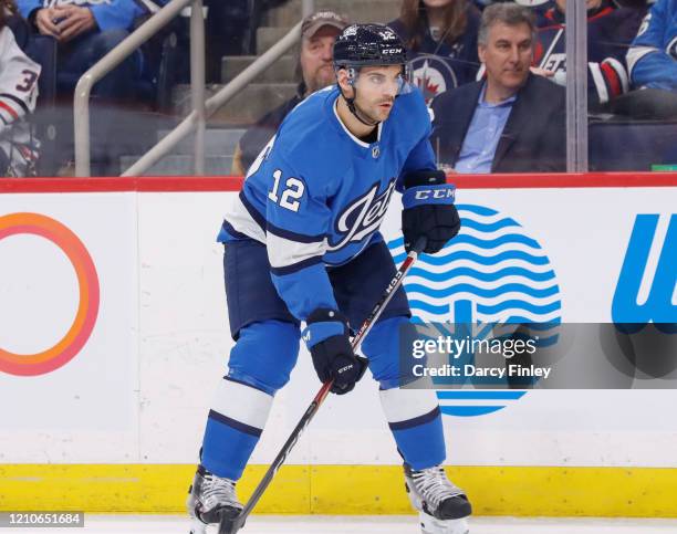 Dylan DeMelo of the Winnipeg Jets gets set during a first period face-off against the Buffalo Sabres at the Bell MTS Place on March 3, 2020 in...