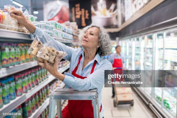 senioren arbeiten im supermarkt - female supermarket stock-fotos und bilder