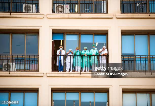 Nurses of the Regional Hospital on a balcony returning the applause. It's a custom every day to show gratitude and applaud fighters of the Covid-19...