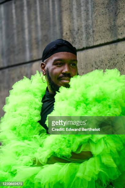 Kiddy Smile wears a black beanie hat, earrings, a neon-green tulle frilly coat, outside Giambattista Valli, during Paris Fashion Week - Womenswear...