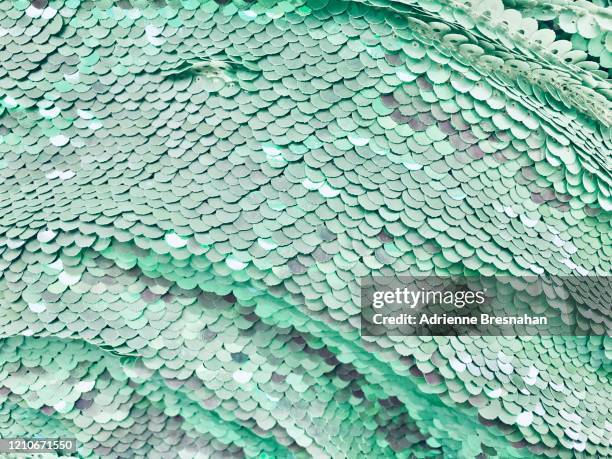 cascade of pale green sequined fabric - sequin stock pictures, royalty-free photos & images