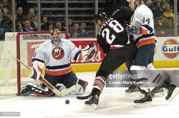 New York Islanders goalie Garth Snow makes a save against Buffalo Sabres center Paul Gaustad in a game at HSBC Arena in Buffalo, New York on December...